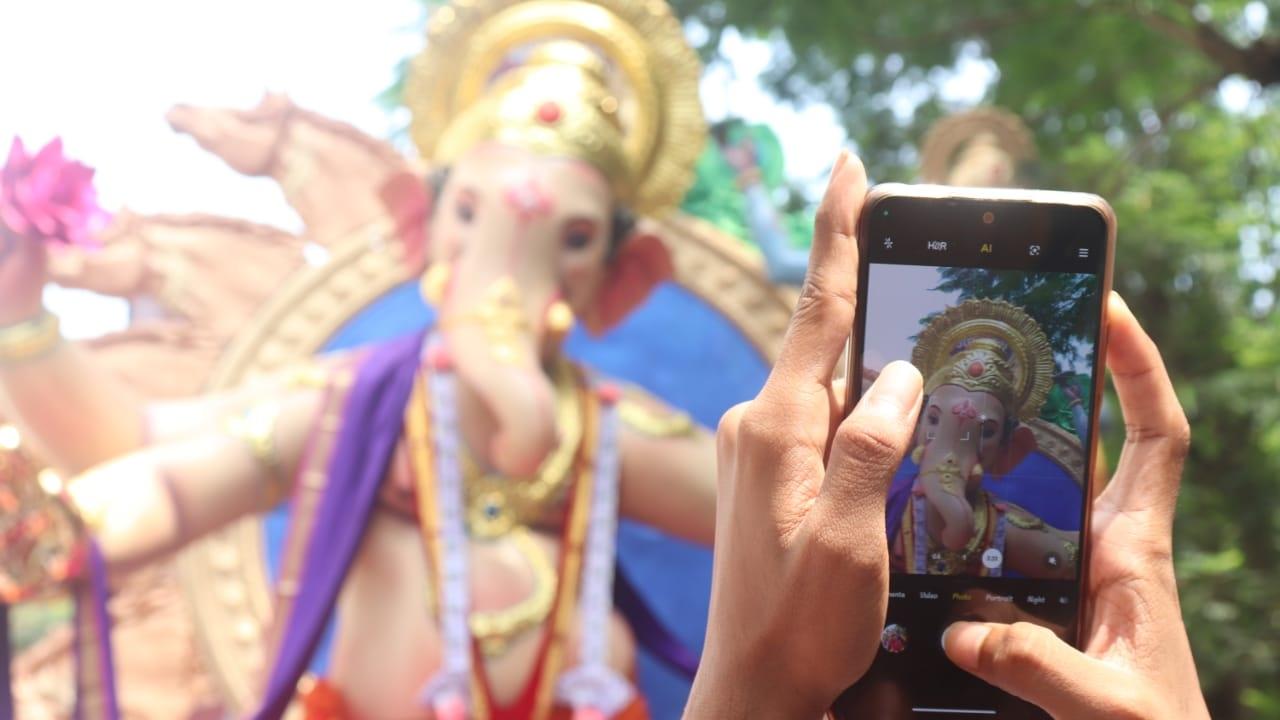 Devotee clicks photo of the Lord Ganesha idol during the procession (Pic/Anurag Ahire)