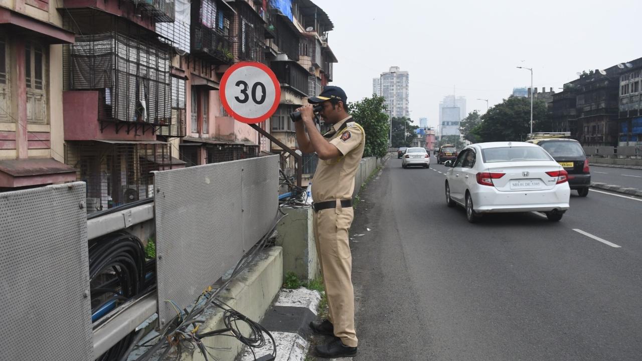Policeman looking through binoculars at J.J bridge flyover during the Eid-e-Milad-un-Nabi procession on Friday