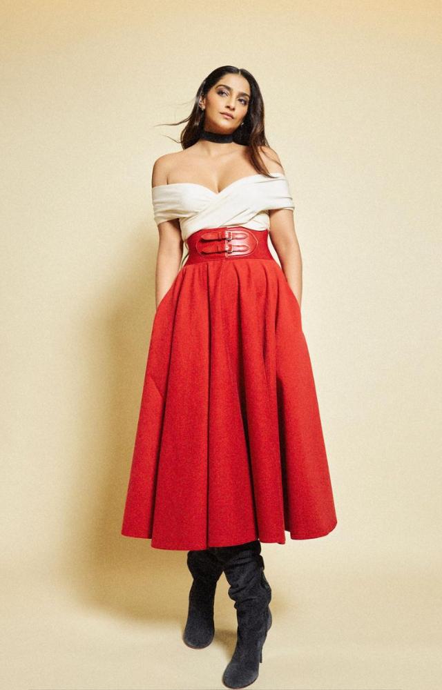 Her ensemble consisted of a stunning top paired harmoniously with a long, flowing red skirt, and it was all cinched together with a fitted belt.