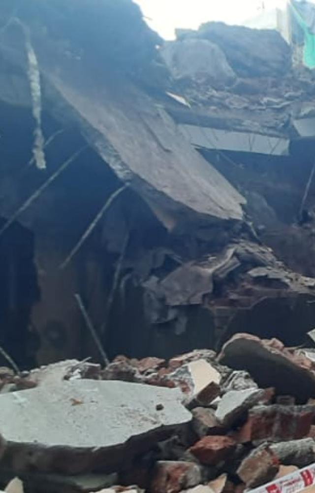 A portion of the building fell on the compound wall of the adjoining structure, causing the wall to collapse, the officials said