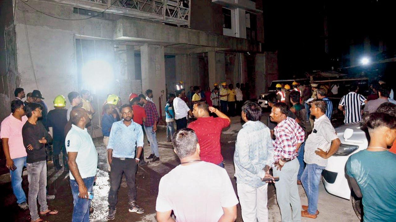 Shocked residents from nearby buildings gather in the compound of the building