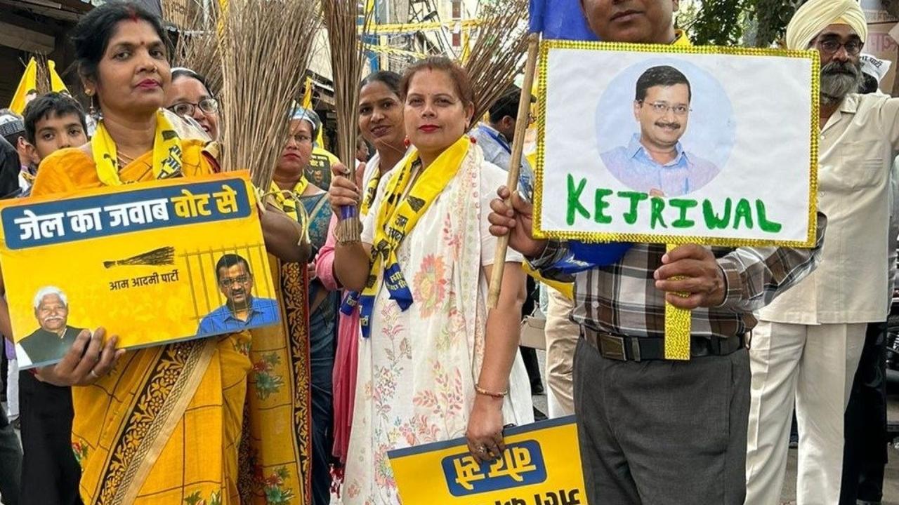 AAP supporters were seen carrying flags with Kejriwal's photo with the 'Jail ka jawab vote se' slogan