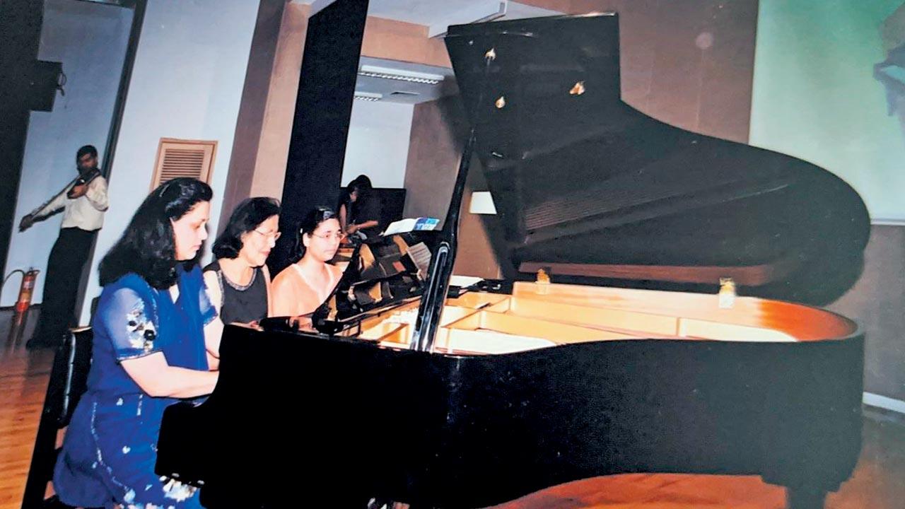 (From left) Blossom Mendonca, Blanche and her granddaughter Bianca play the piano during a performance