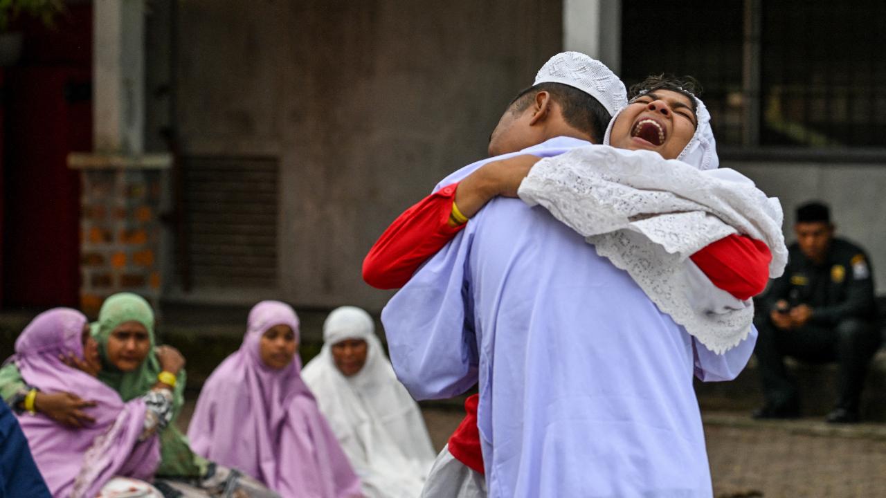 Rohingya refugees embrace each other after taking part in Eid al-Fitr prayers, marking the end of the holy month of Ramadan, at a temporary shelter in Meulaboh, Indonesia's Aceh province on April 10