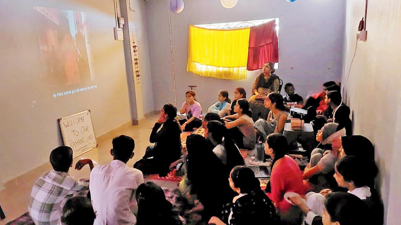Participants watch a film during a screening at the Jogeshwari space