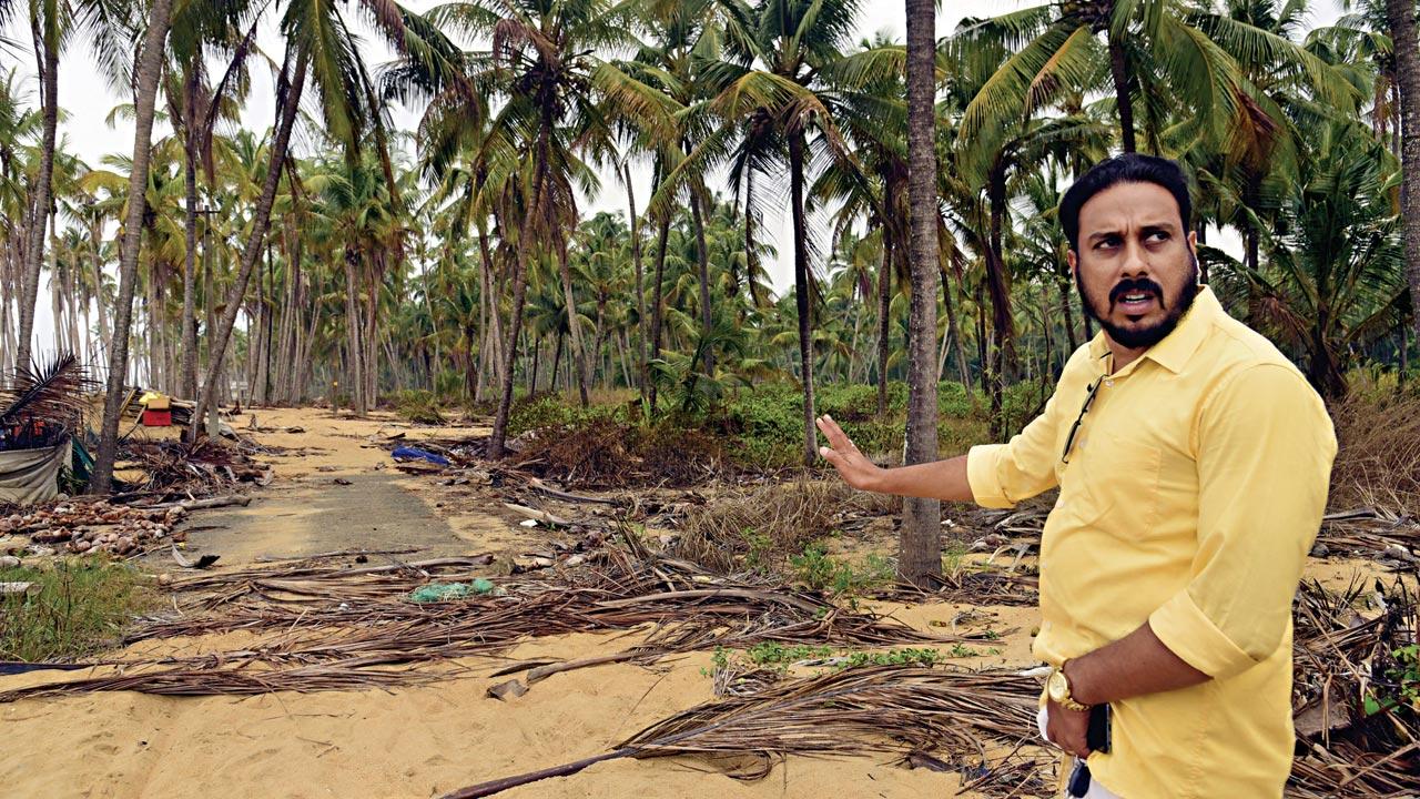 Shijil Chulliparambil points at a submerged tar road, through which vehicles used to enter the village. The pipeline connection set up to provide drinking water for the villagers was weak and hence, the government provided water through tankers to the island free of charge. However, after sand filled up the main tar road after the flood, water tankers are now unable to enter the village  