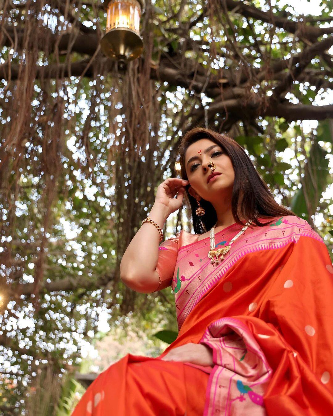 In this look, she wore an orange saree with a big pink border, which struck a balancing contrast. The actress left her hair open and put on minimal makeup