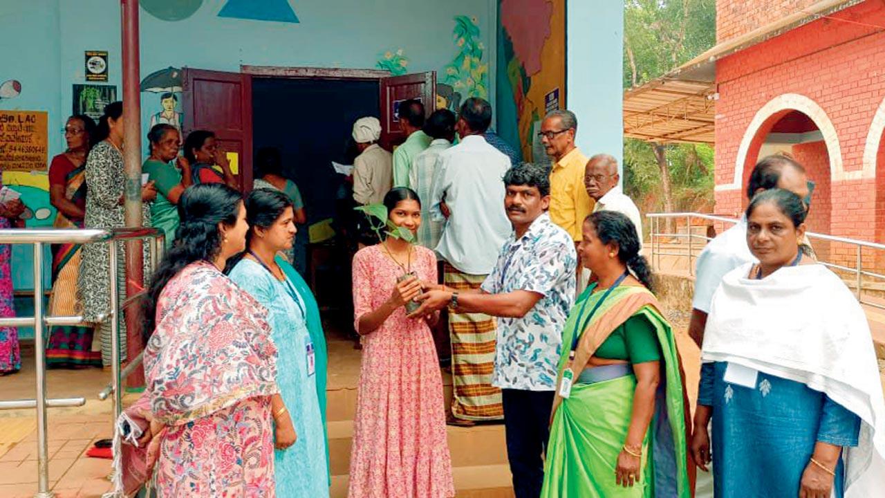 A first time voter felicitated with a pepper sapling by district administration of Wayanad