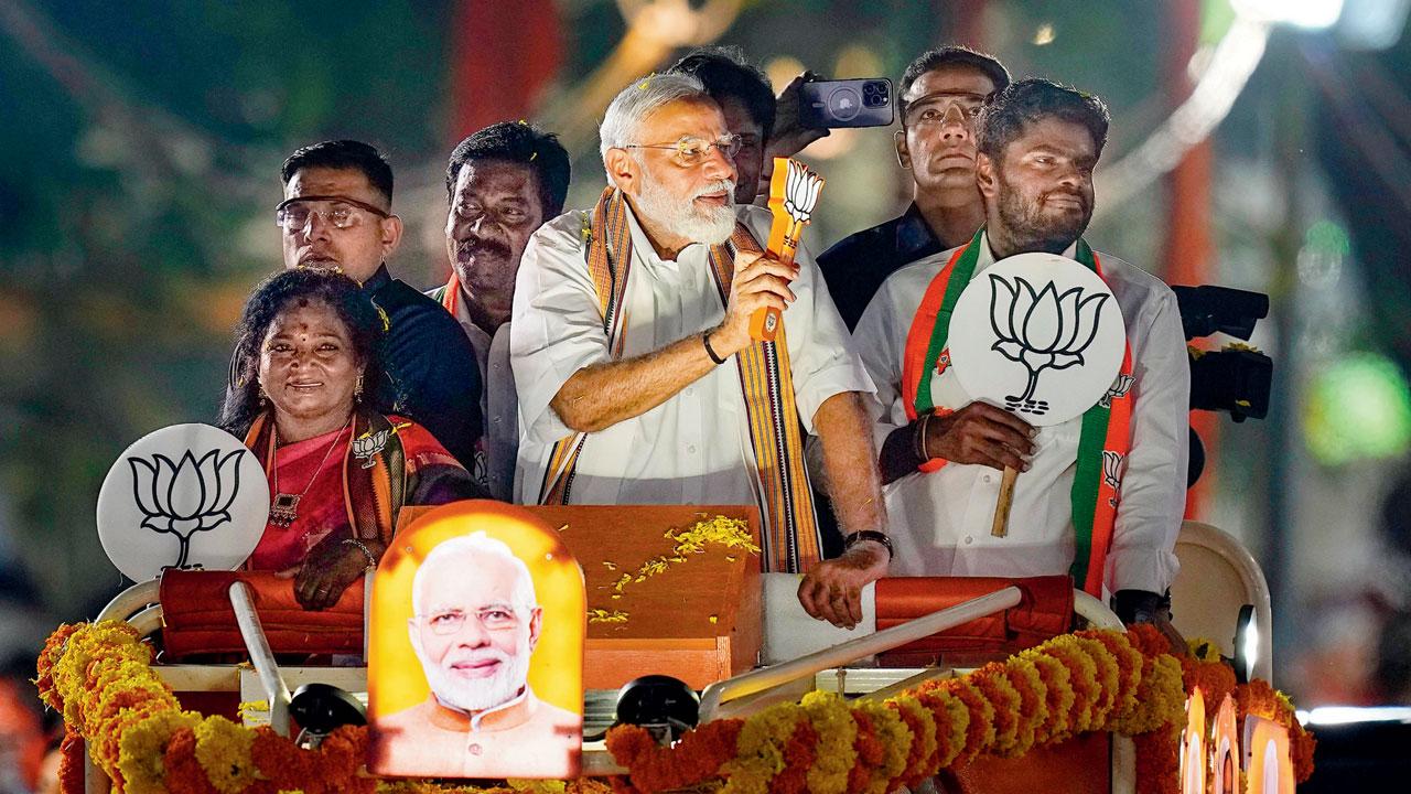 Prime Minister Narendra Modi greets supporters during a roadshow in support of the BJP’s candidate from South Chennai constituency, Tamilisai Soundararajan (left), in Chennai, Tuesday, April 9. PIC/PTI