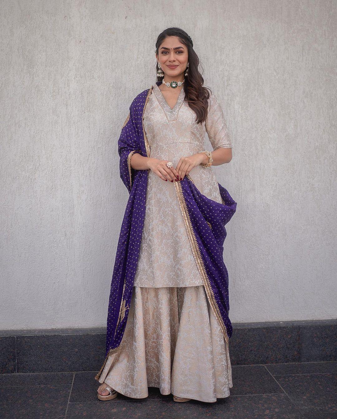 In this beautiful look, Mrunal wore an off-white embroidered kurta paired with a matching sharara, complemented by a purple dupatta