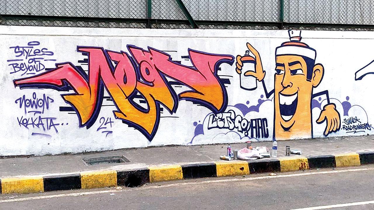 A wall in Marol sports a tag and a caricature painted by Murmu and SMACK
