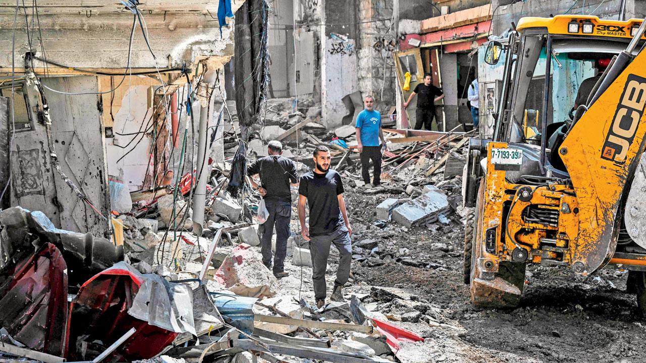 Palestinians inspect the damage to a street after a raid by Israeli forces in the Nur Shams camp for Palestinian refugees in the occupied West Bank on Sunday