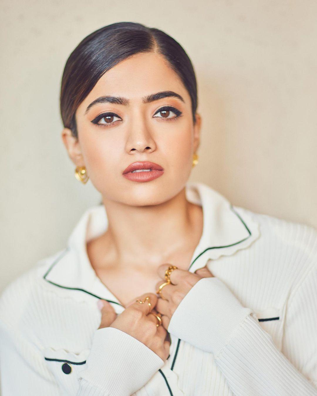 Forgoing heavy jewelry, she wore golden studs to enhance her look. Rashmika tied her hair in a chic ponytail. With nude makeup, Rashmika looked stunning