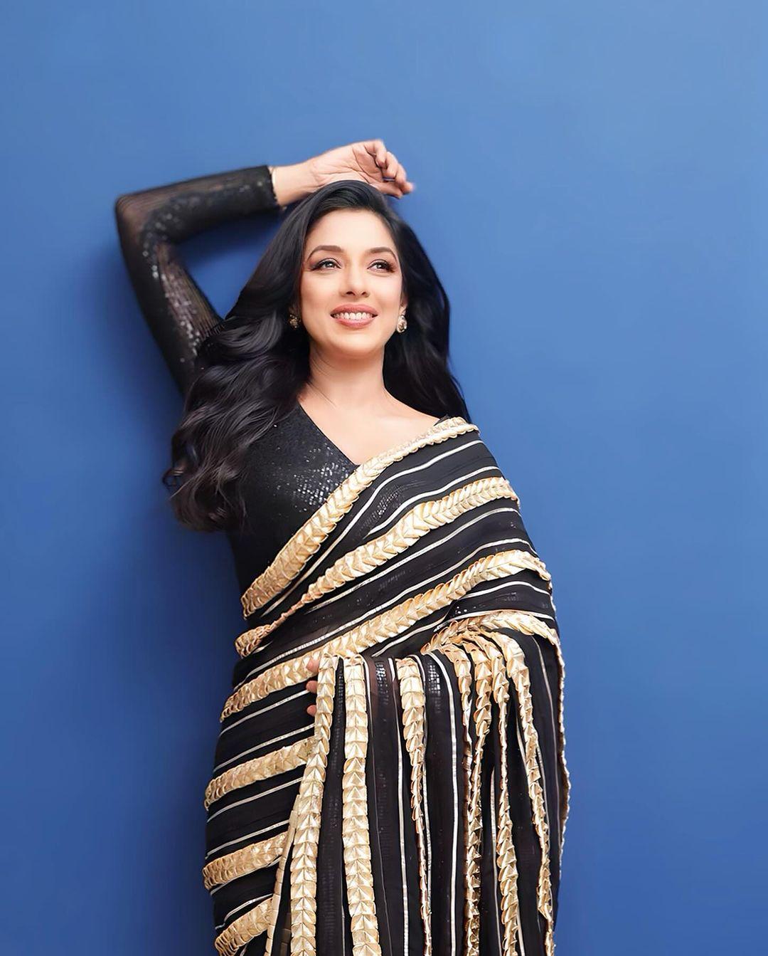 The actress paired the saree with a net full-sleeve black blouse and kept it simple with studs, leaving her hair open in soft curls