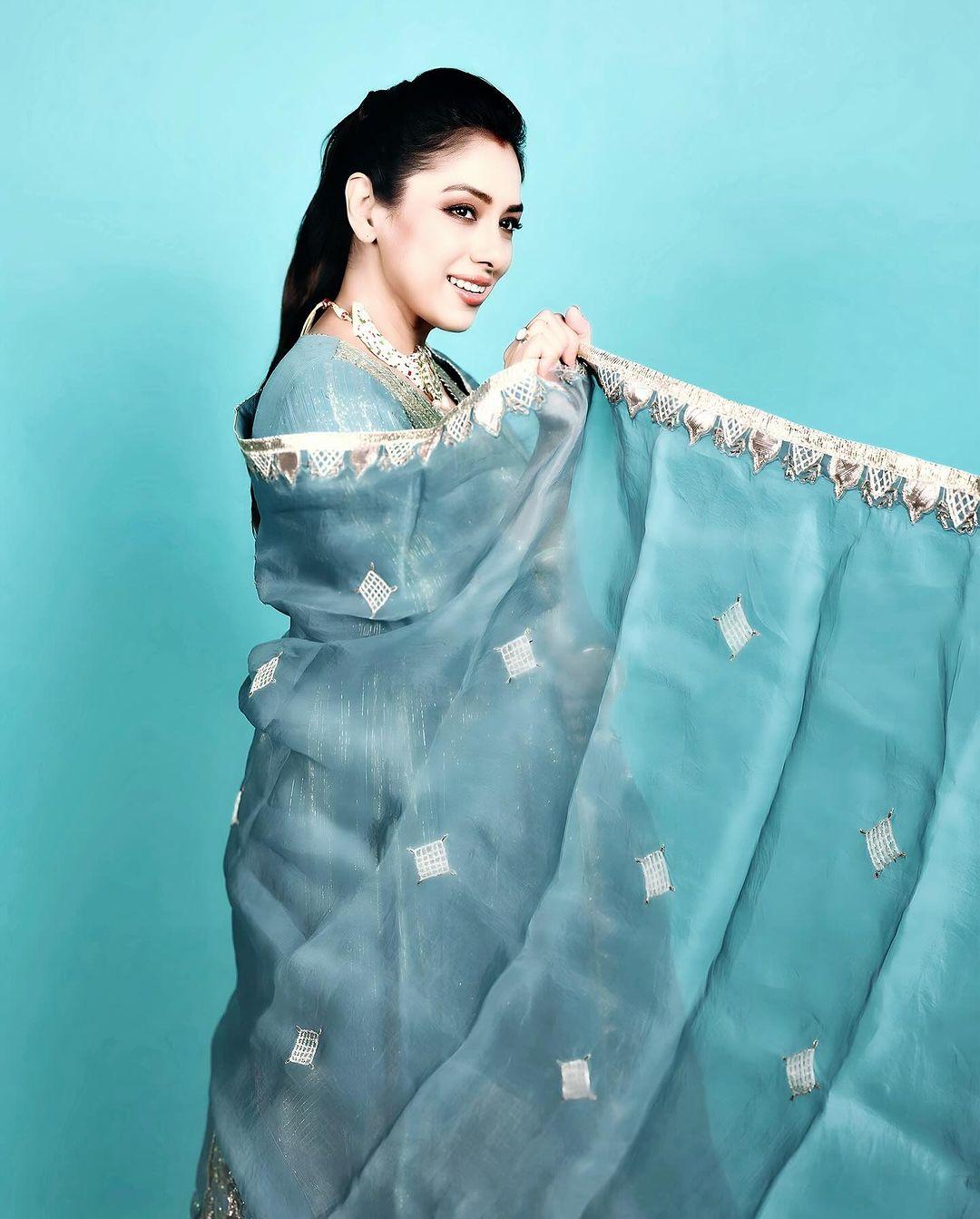 Feeling cool is easy with blue, and Rupali's saree in this hue is proof. The plain blue saree with a golden border and simple embroidery makes it a perfect fit for any puja in the house