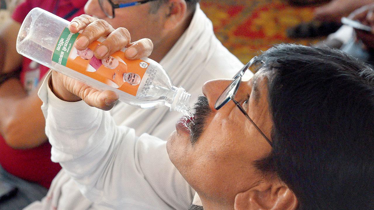 An audience member sips from a bottle bearing the PM’s image at BJP president J P Nadda’s meeting at Circus Maidan, Gondia on April 12. Pic/Satej Shinde