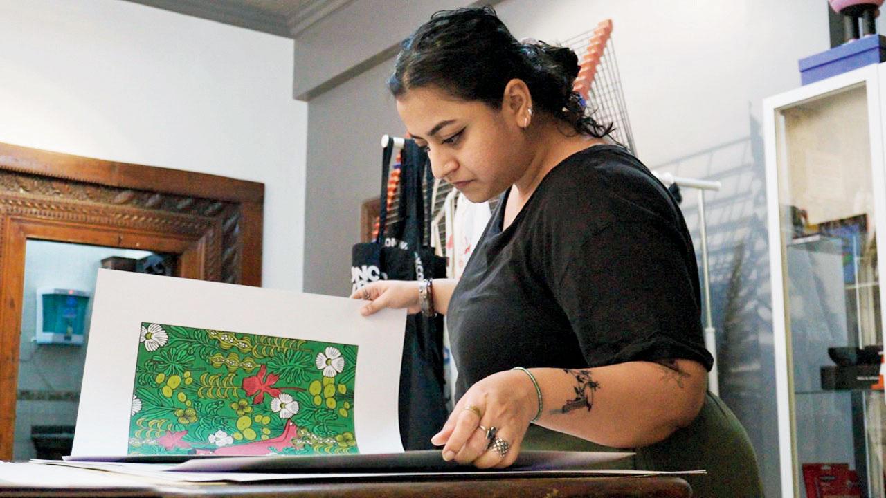 A woman browses through printed artworks at the previous edition of the event