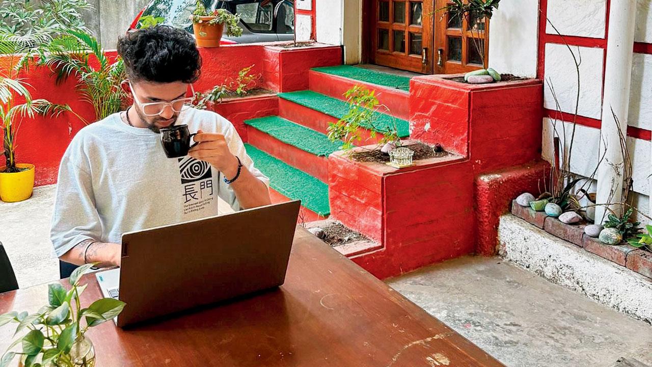 A member of Workbay works in the outdoor seating area of the café-turned-workspace 