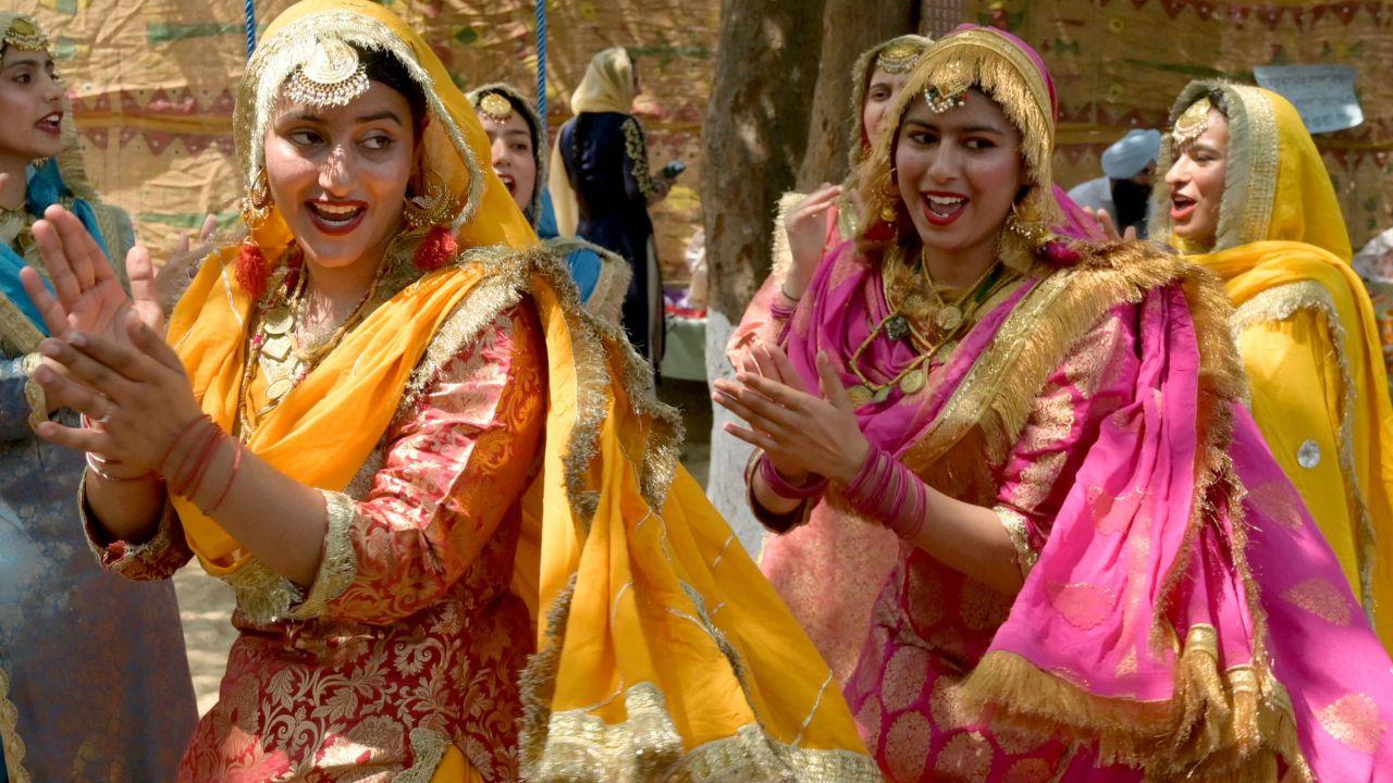 College girls wear bright coloured traditional outfits and dance during a fair held ahead of Baisakhi festival at the Khalsa College in Amritsar (Photo by Narinder NANU / AFP)