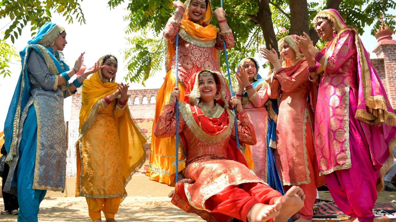 College girls wearing traditional outfits enjoy a swing during a fair held ahead of Baisakhi festival at the Khalsa College in Amritsar. (Photo by Narinder NANU / AFP)