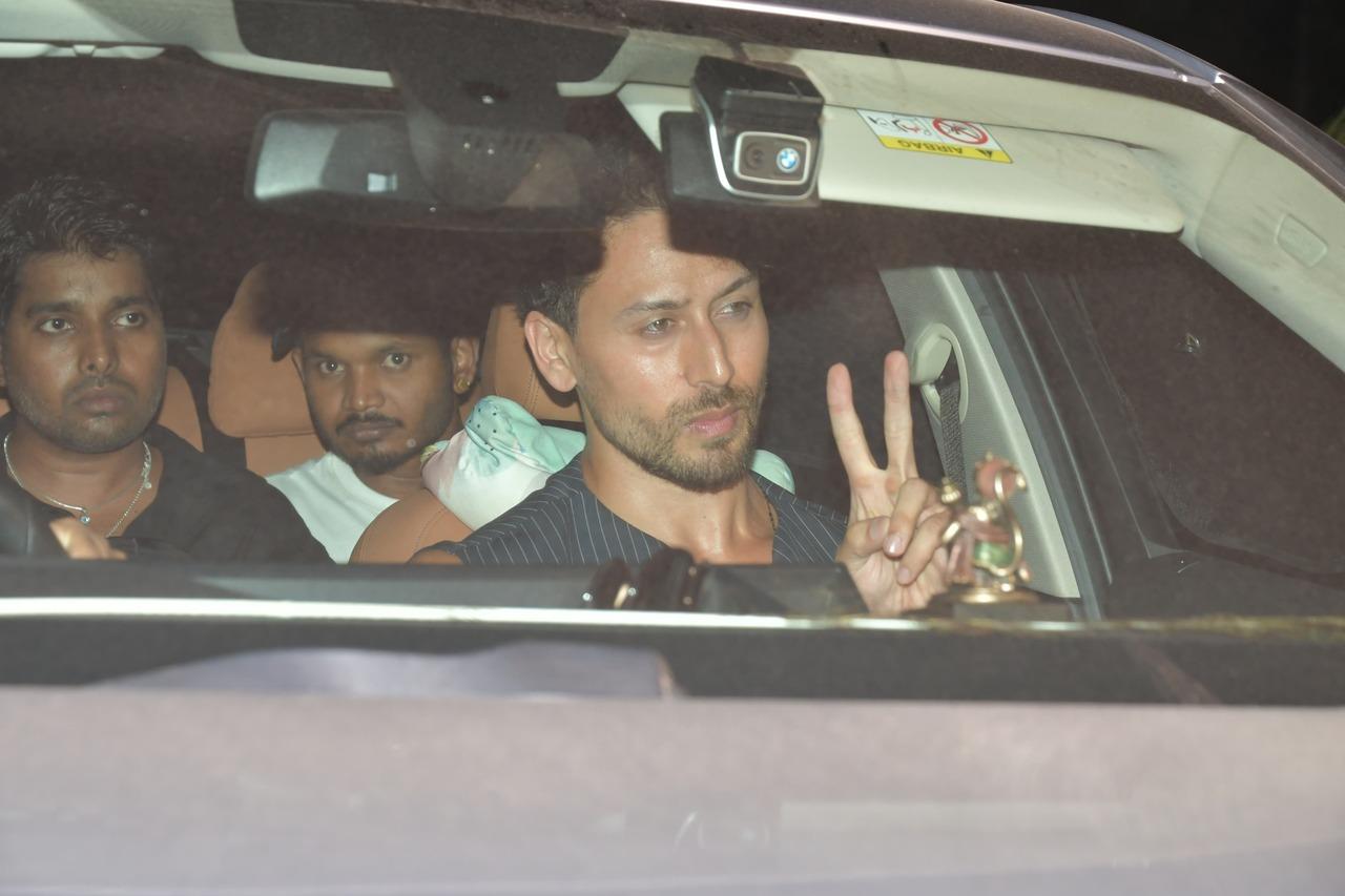 Tiger Shroff displays the victory symbol as he arrives for the screening