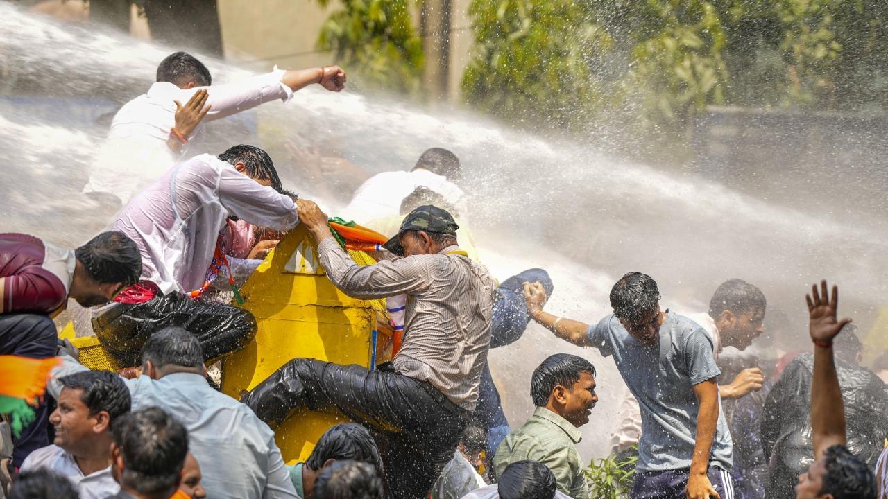 Security personnel use water cannon to disperse BJP workers protesting against CM Arvind Kejriwal. Pics/PTI
