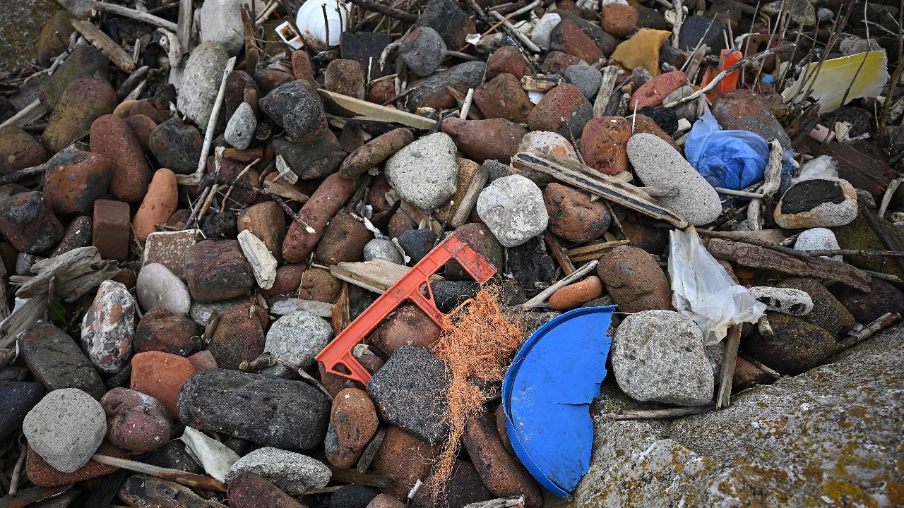 Rubbish including fragments of broken plastic items, rope, and plastic bags, is pictured, washed up on the shore from the sea, in Crosby, northwest England on April 22, 2024. Earth Day, observed annually on April 22, was first celebrated in 1970, and now includes a wide range of events across more than 193 countries, demonstrating support for environmental protection (Photo by Paul ELLIS/AFP)