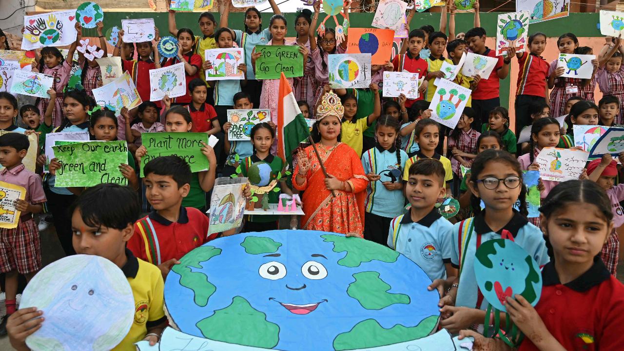 Students hold their paintings and models with environmental themes as they gather on the occasion of 'Earth Day' at a school in Amritsar on April 22, 2024. (Photo by Narinder NANU/AFP)