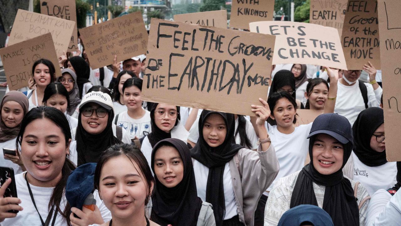Participants hold placards as they march on a street ahead of Earth Day on April 22, the annual environmental awareness day, in Jakarta on April 21, 2024 (Photo by Yasuyoshi CHIBA/AFP)