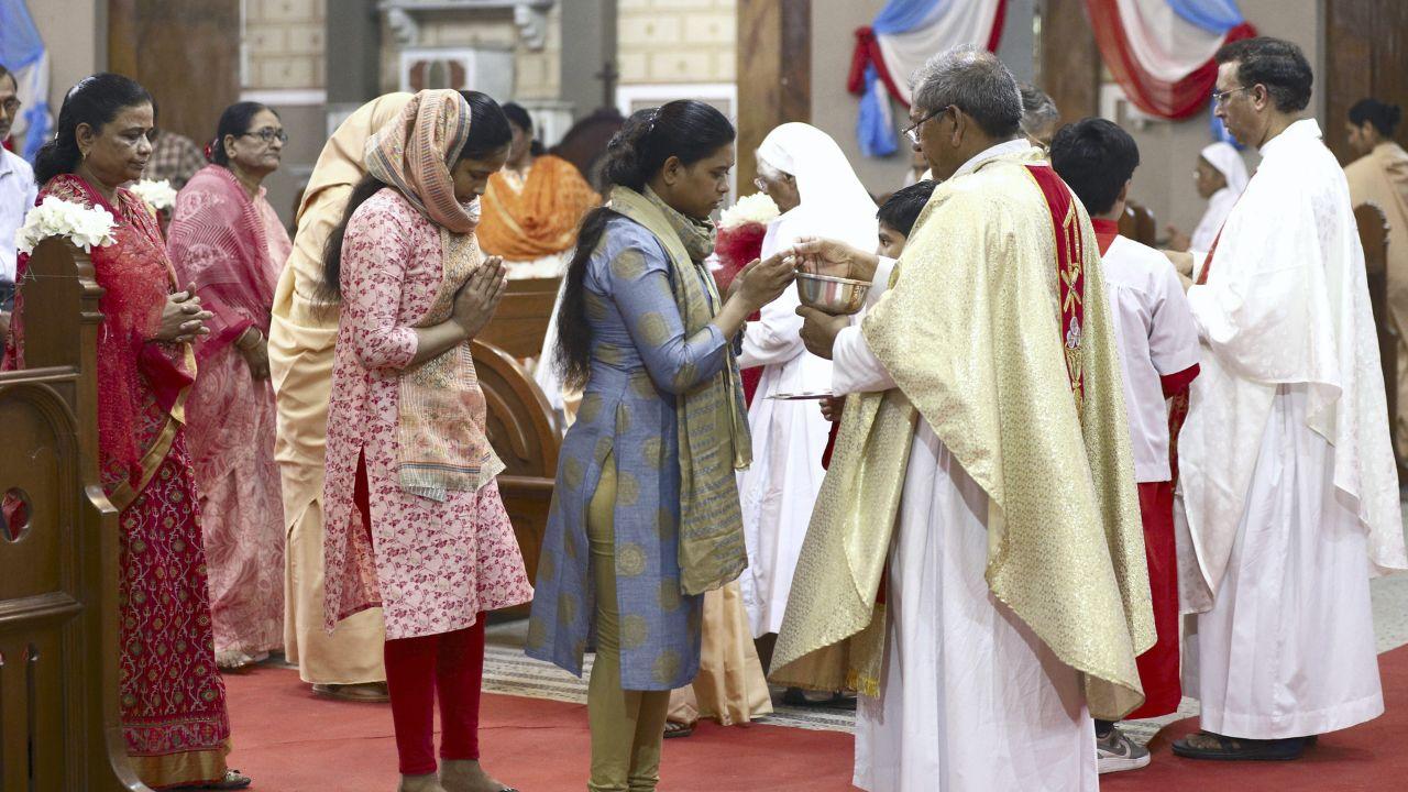 Christian devotees receive communion after a solemn mass on the occasion of Easter Sunday at ST Joseph Cathedral, in Prayagraj. Photo Courtesy: PTI