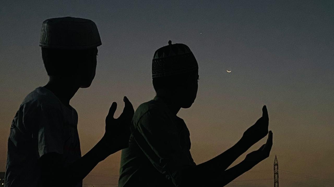 Children watch the crescent moon from their building's terrace at Wadala in Mumbai on Wednesday. Pics/Shadab Khan and Nimesh Dave