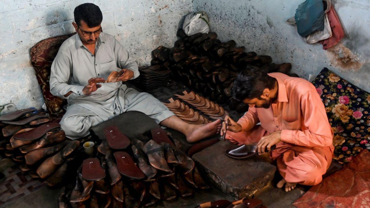 Workers make traditional slippers at a workshop in Karachi ahead of the Eid al-Fitr celebrations. (Photo by Rizwan TABASSUM / AFP)