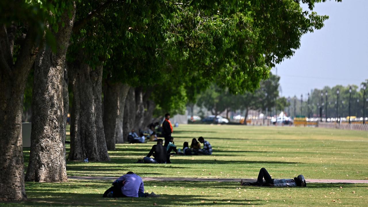 People rest at the lawns of the India Gate on a hot summer day in New Delhi. Extensive scientific research has found climate change is causing heat waves to become longer, more frequent and more intense (Photo by Sajjad HUSSAIN/AFP)