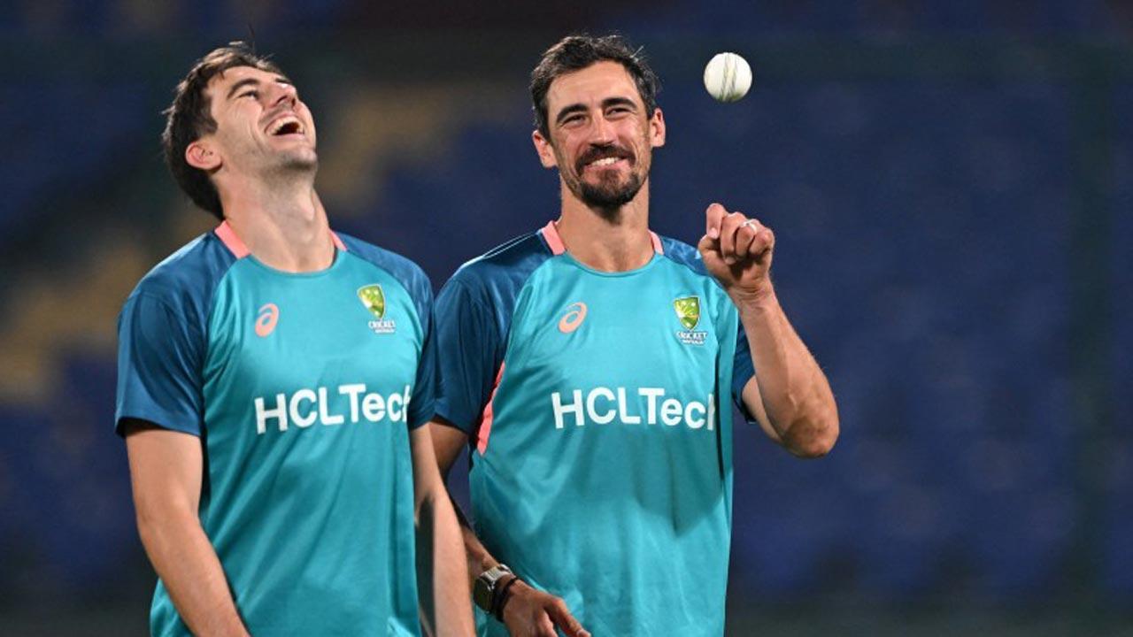 Pat Cummins (L) and Mitchell Starc speak during a practice session. Pic/AFP