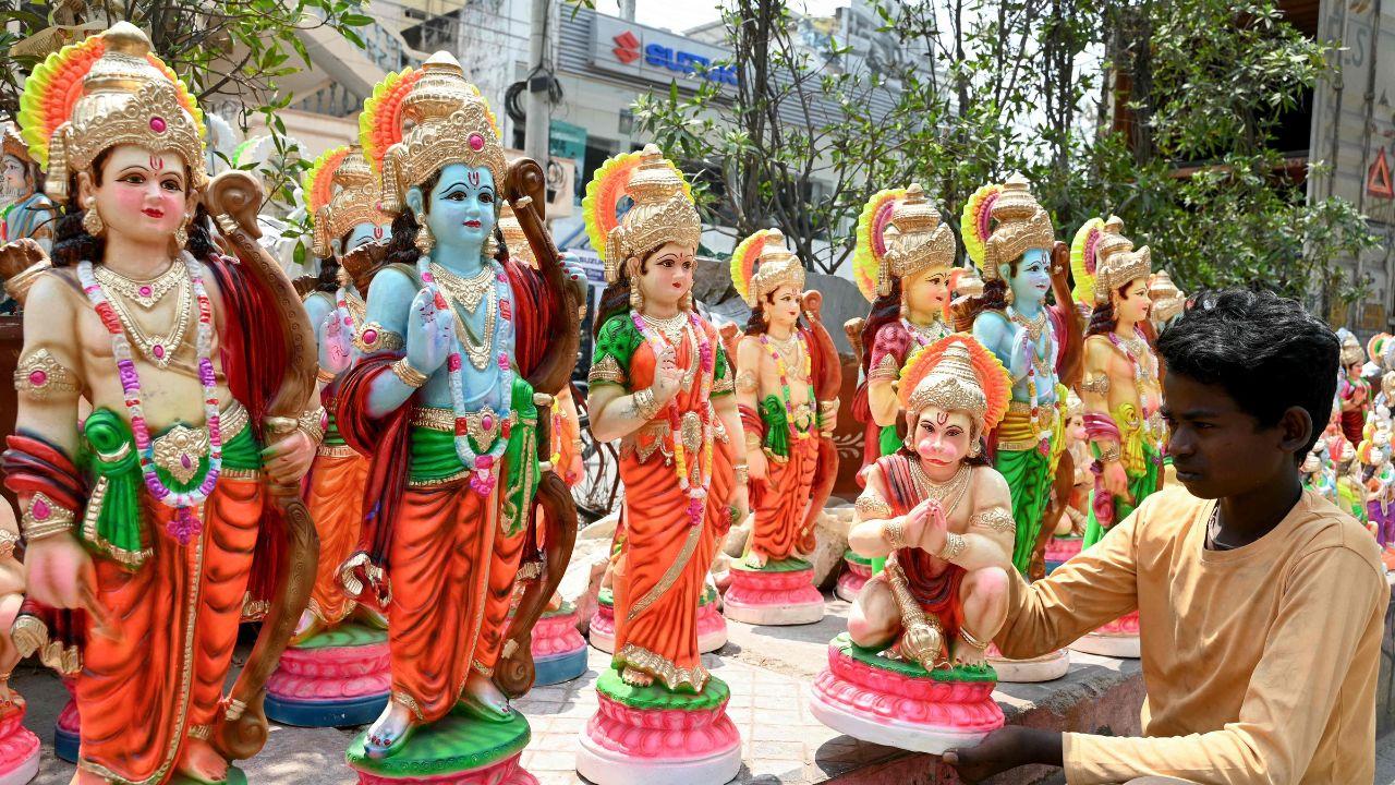 A vendor waiting for customers arranges idols of Hindu deities along a roadside in Hyderabad on April 16, 2024, on the eve of Ram Navami festival. (Photo by Noah SEELAM / AFP)