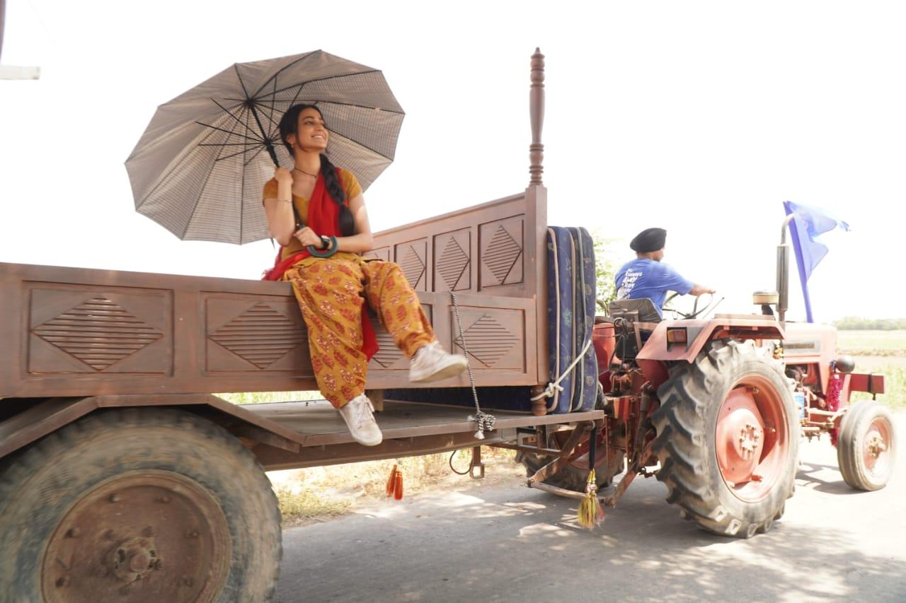 The actress poses on a wooden bed, lying on a tractor, as she enjoys the shooting process