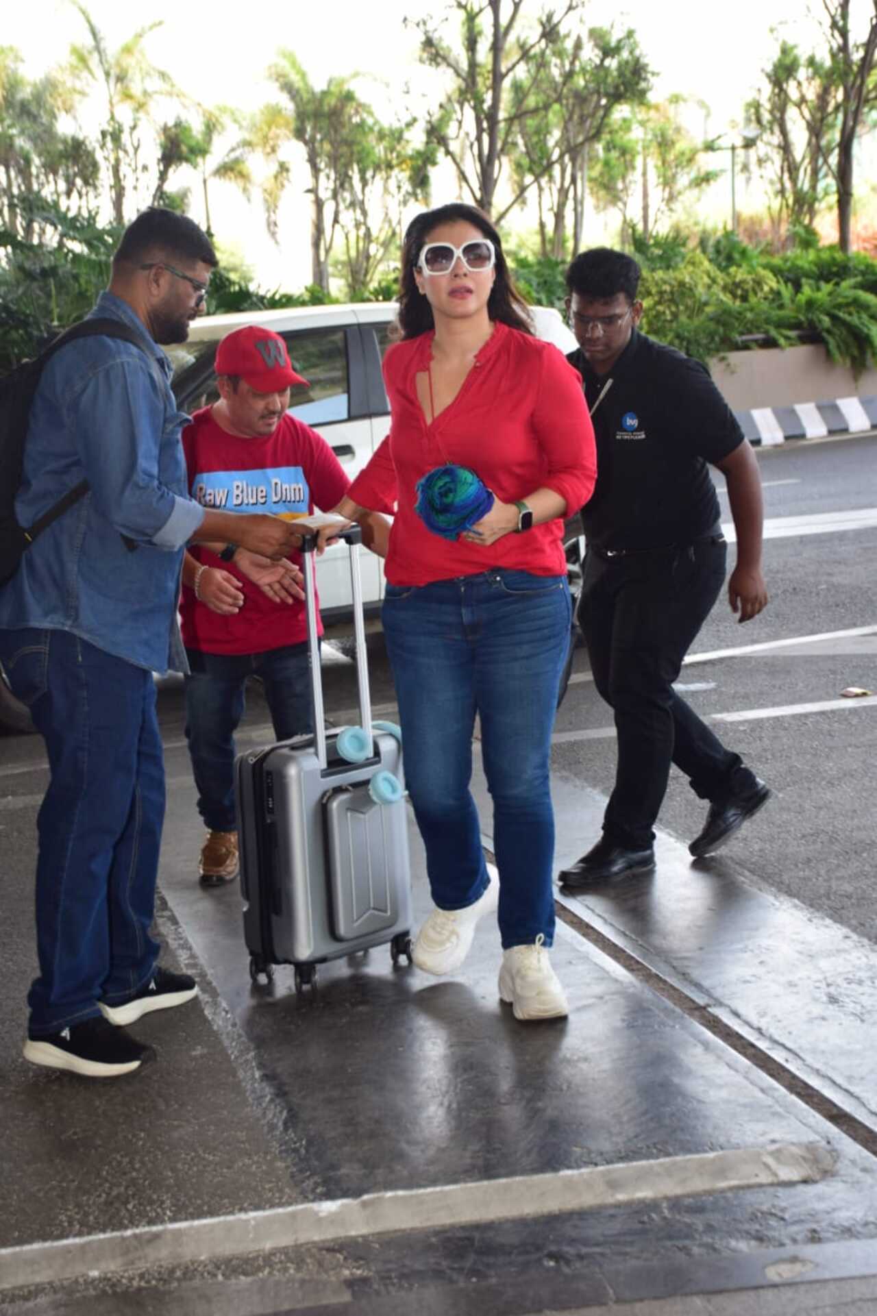 Kajol was seen in a red top and blue denims and white-framed sunglasses as she arrived at the Mumbai airport