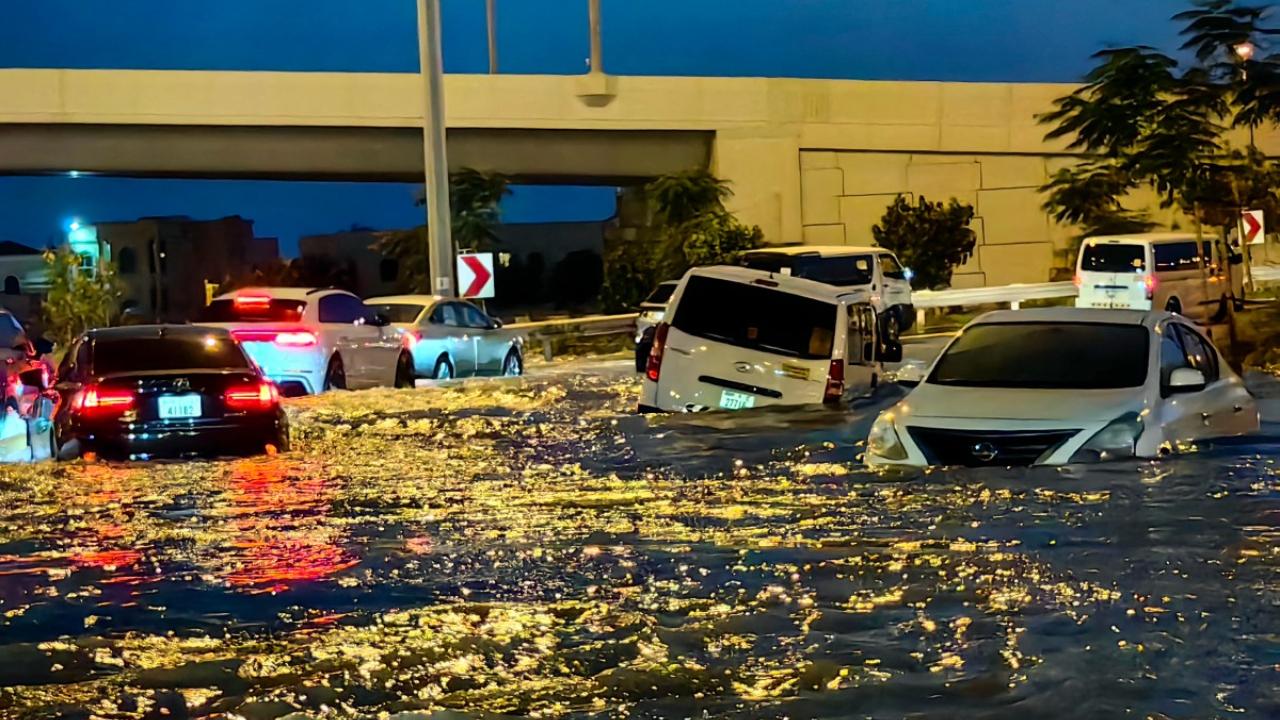Cars drive in a flooded street following heavy rains in Dubai on April 17, 2024. Dubai, the Middle East's financial centre, has been paralysed by the torrential rain that caused floods across the UAE and Bahrain and left 18 dead in Oman on April 14 and 15. (Photo by Giuseppe CACACE/AFP)