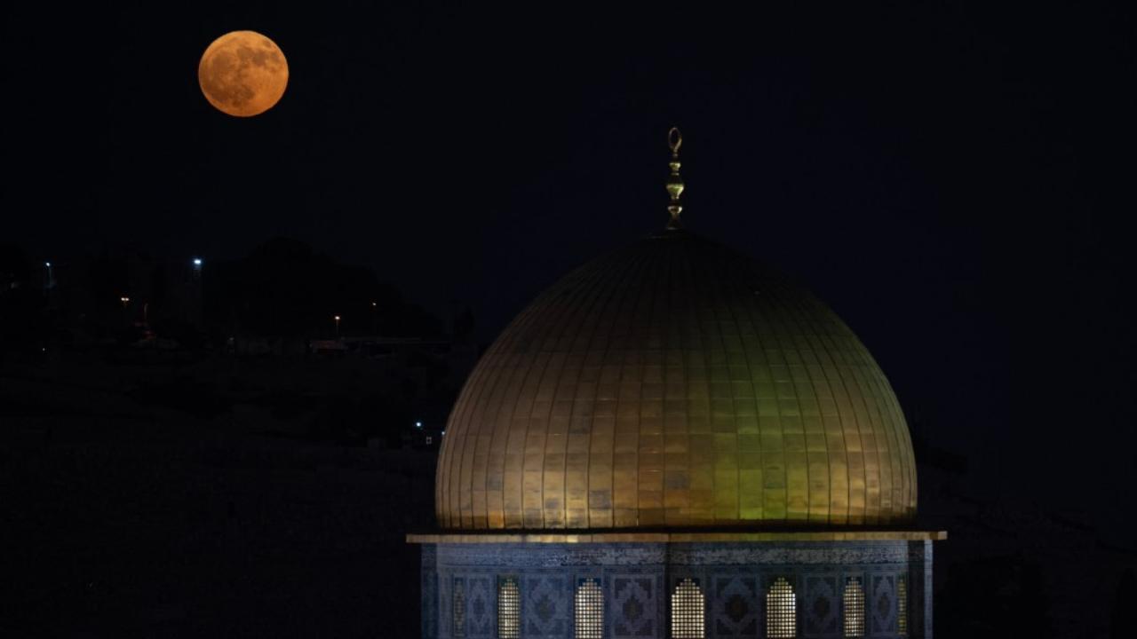 The Blue Moon rises behind the Dome of the Rock mosque in Old Jerusalem's al-Aqsa mosque compound in on August 19, 2024