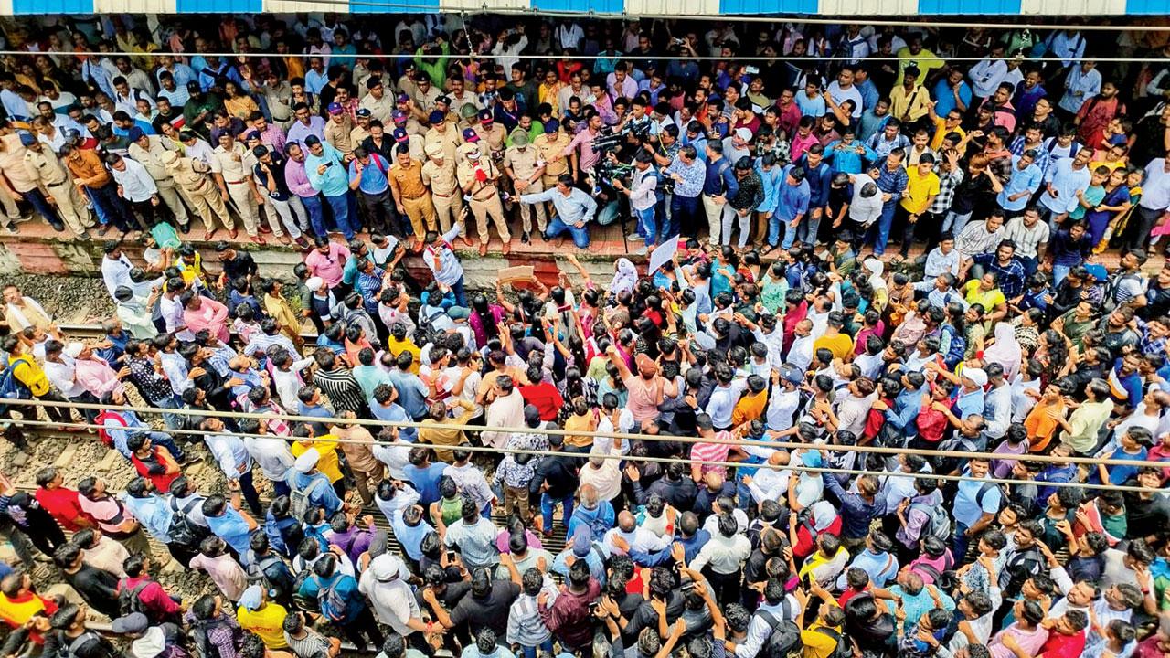 Cops speak with people blocking railway tracks. Pic/PTI