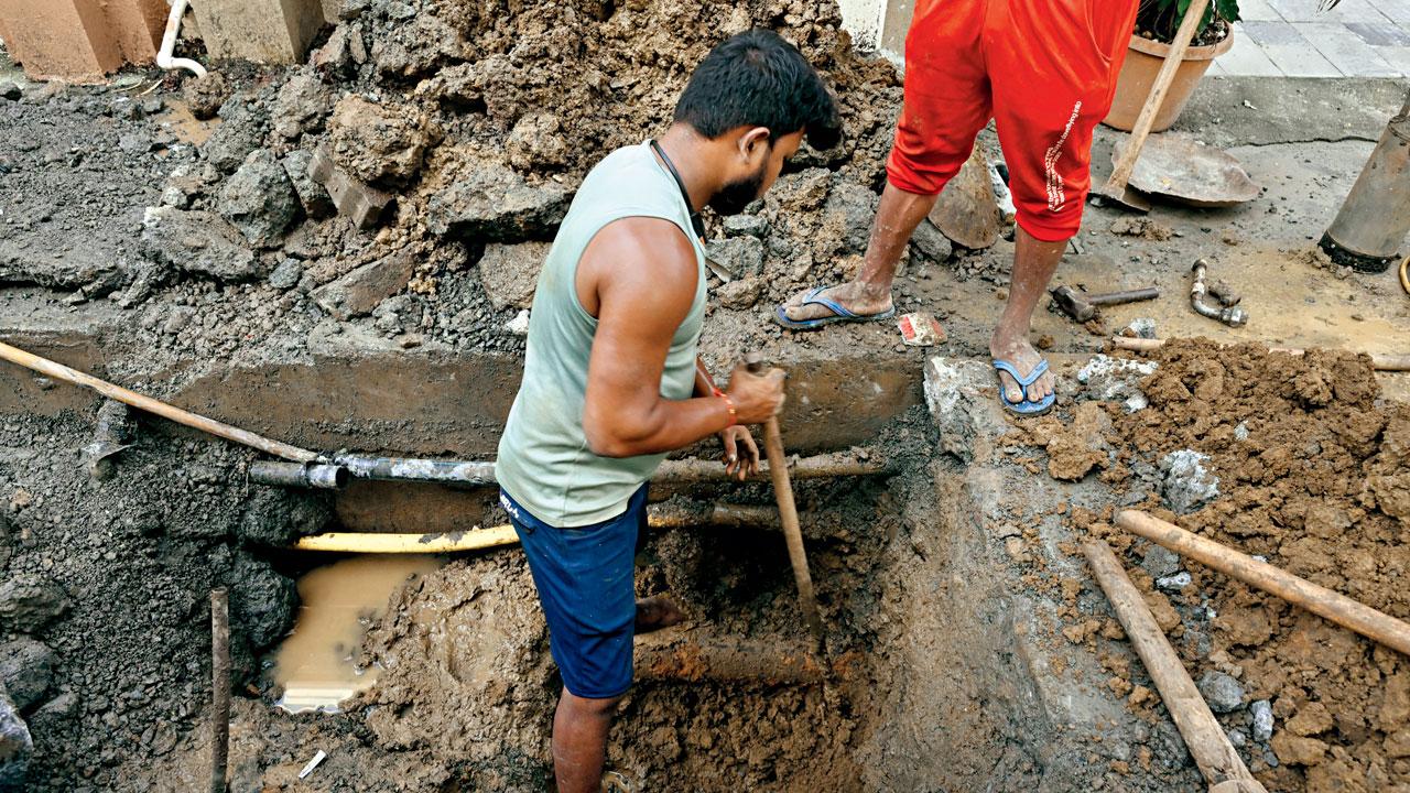 The road near D’Monte Park in Bandra West is dug up on Thursday to locate the source of the contamination. Pics/Atul Kamble