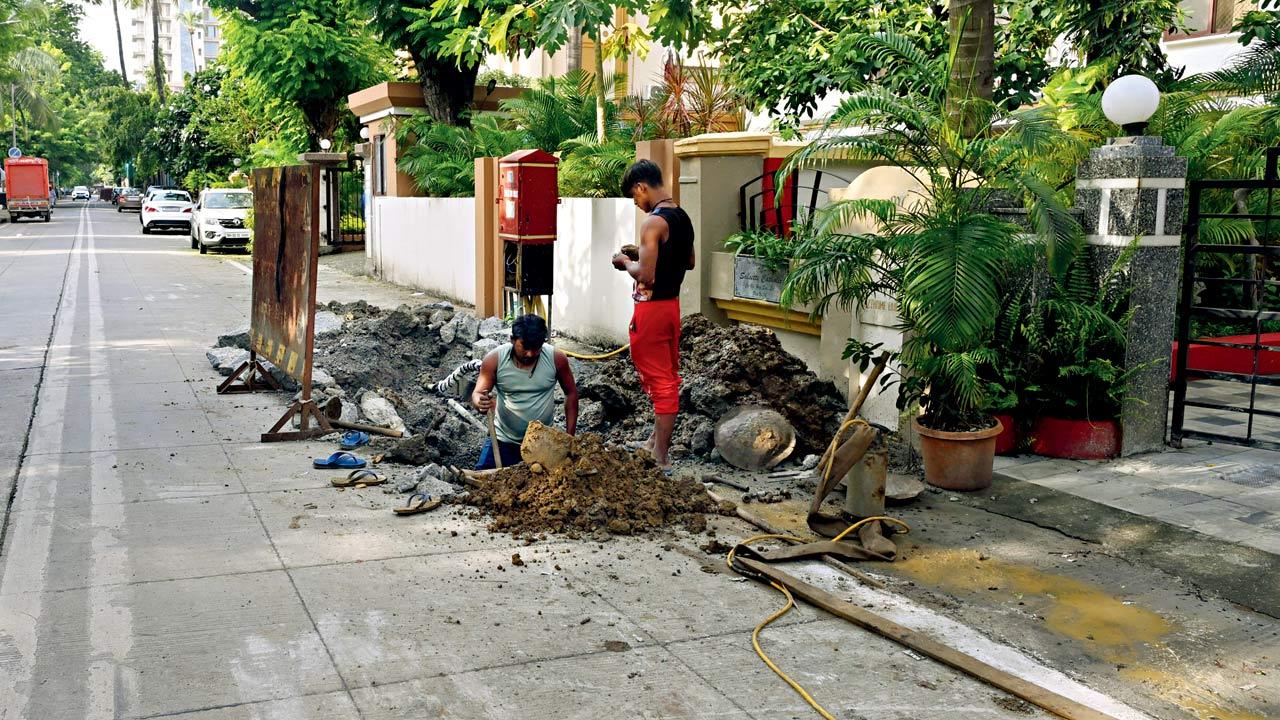 A concrete road near D’Monte Park in Bandra West is dug up on Thursday to locate the source of the contamination. Pic/Atul Kamble