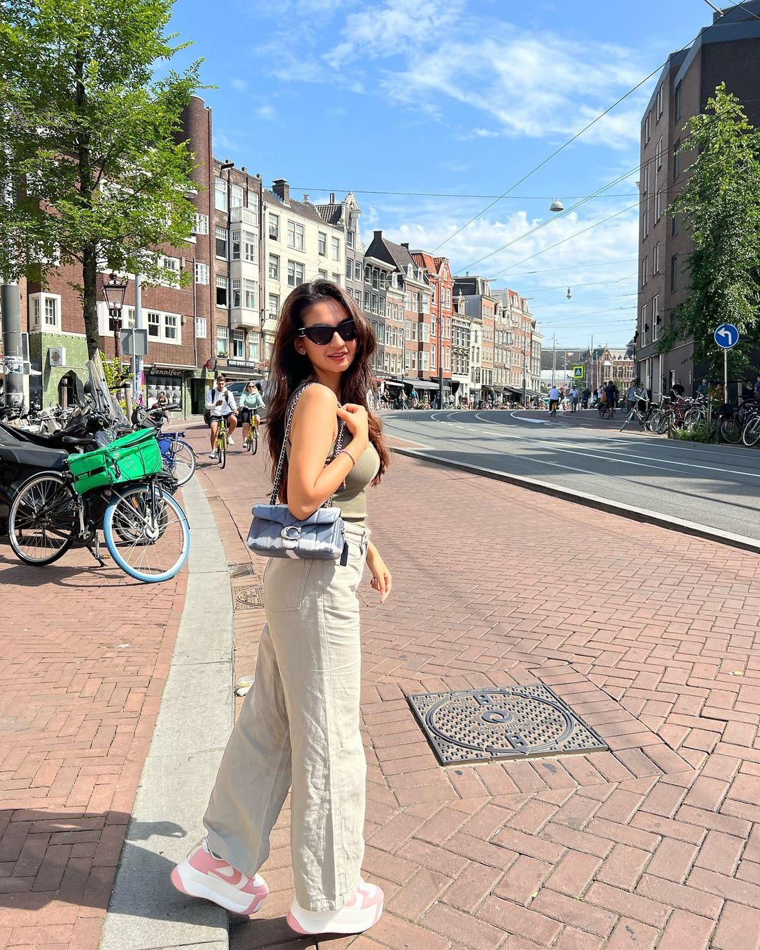 The first photo dump from Anushka Sen's Amsterdam vacation has her wearing cool beige pants paired with a green crop top