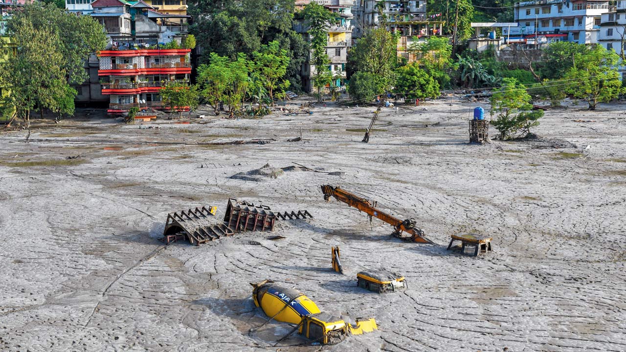 Construction vehicles are seen covered in debris caused by flash floods after a lake burst in Rangpo along the Teesta River. Scientist had declared the site a hazard for months after the incident. Pic/Getty Images