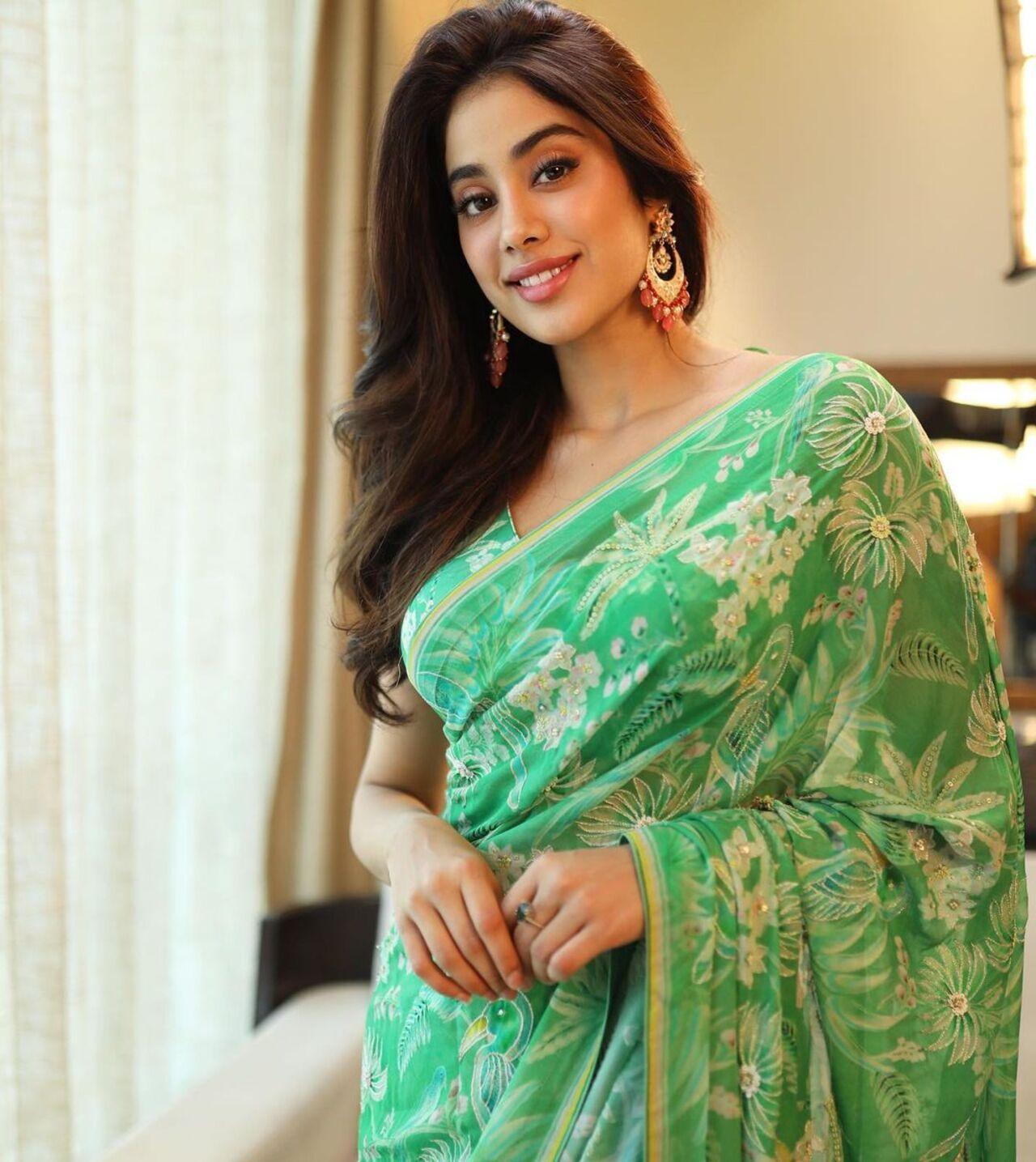 The actress wore a stunning printed green saree and paired it with a strappy blouse. She left her hair open in loose curls while establishing a perfect contrast by pairing it with red earrings