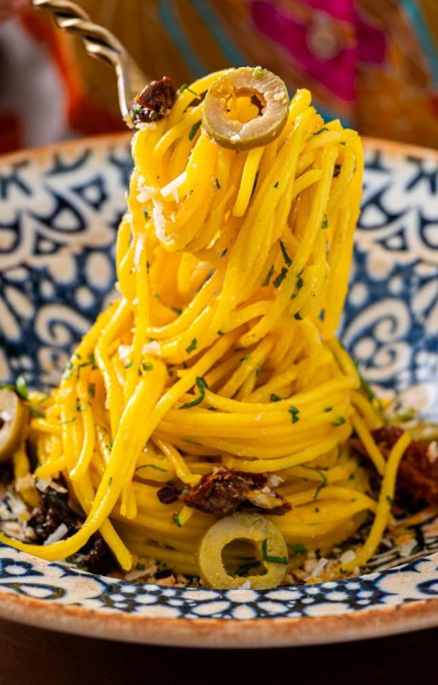 The Spaghetti allo Zafferano presents strands of pasta enveloped in a saffron sauce, creating a comforting yet elegant dish