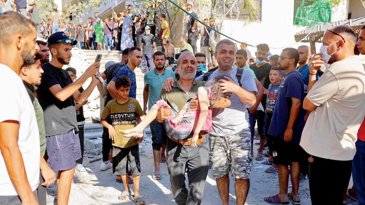 A man carries the body of a girl killed at the school. Pics/AFP