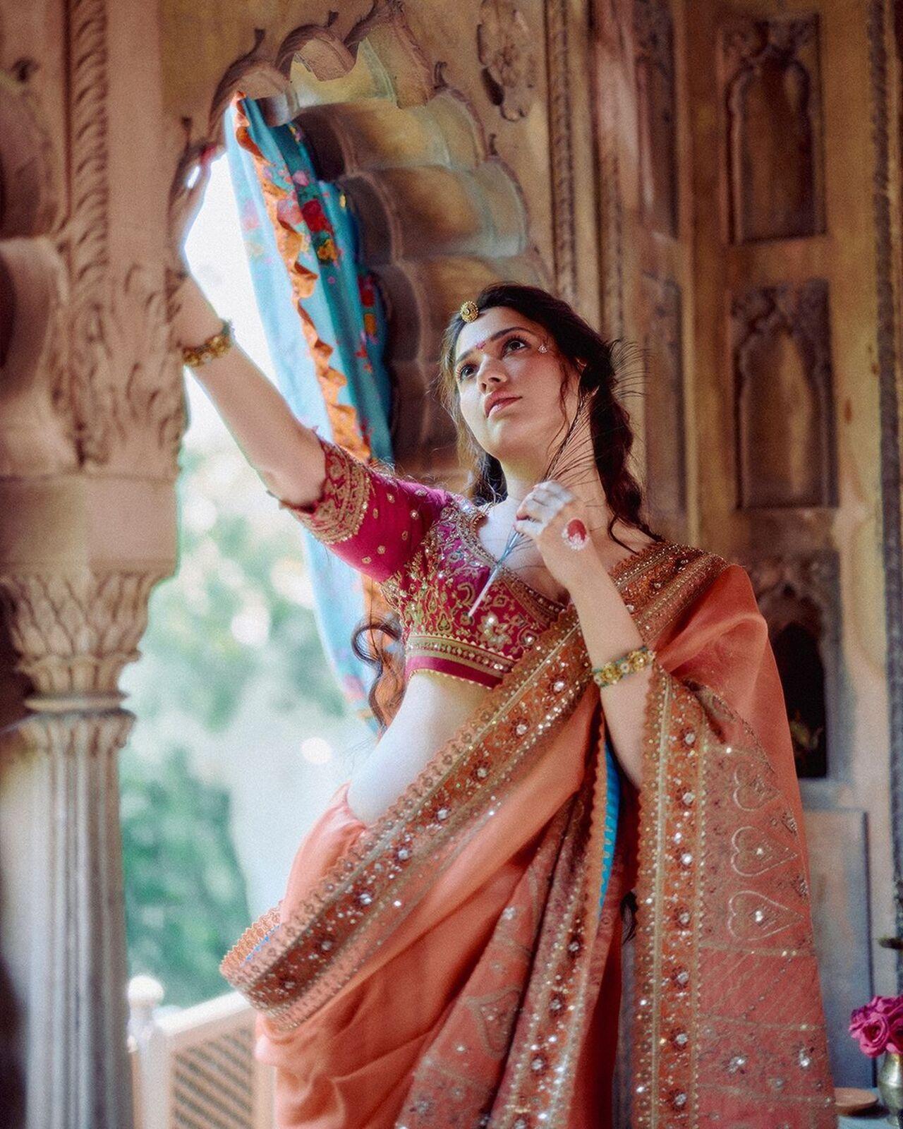 The actress wore a beautiful peach-colored lehenga decorated with embellishments all over it. She paired the lehenga with a dark pink-colored blouse