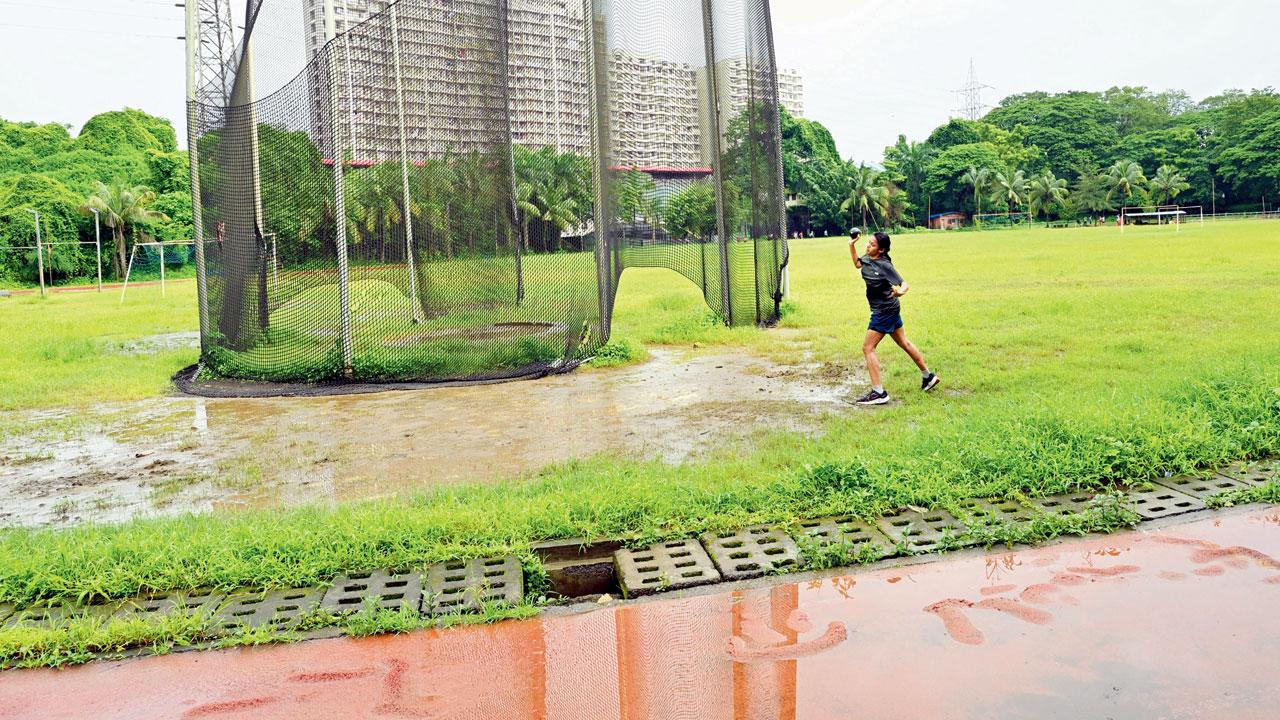 A female athlete practising shot put in poor ground conditions
