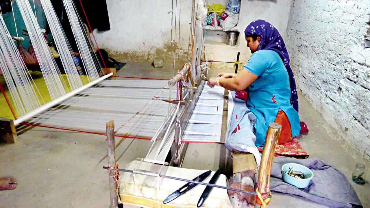 A traditional weaver works on a Kota Doria pit loom